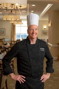 Chef poses for camera between creating luxury meals